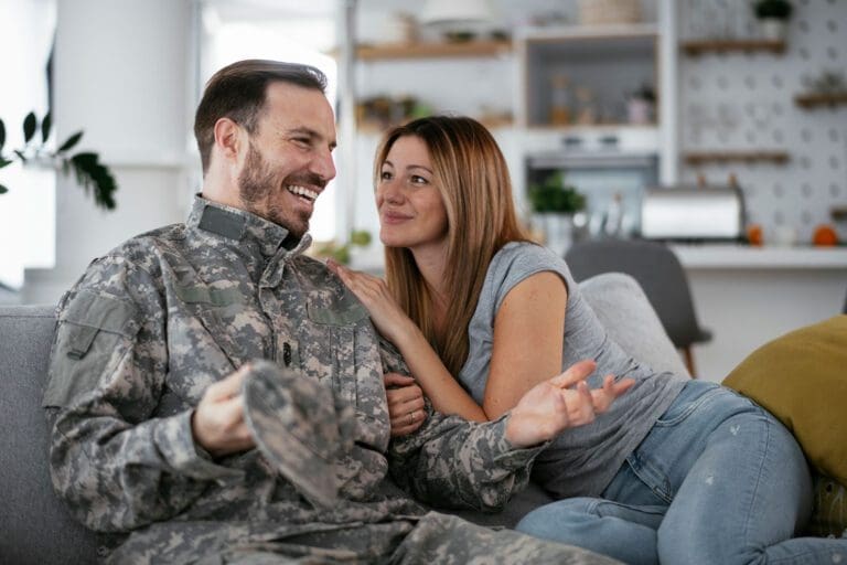 Featured image for Military Spouse Benefits, showing a male Servicemember and his wife on the couch