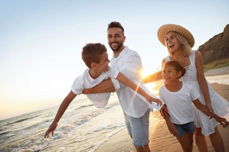 Featured image for American Forces Travel, showing a happy military family on vacation by the beach