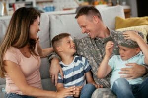 Featured image for TRICARE, showing a happy military family in their living room