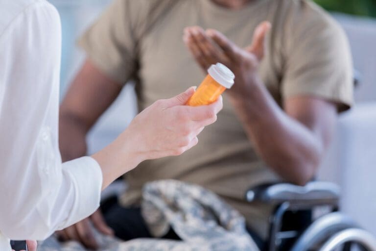 Featured image for VA Health Care, showing a female doctor giving medication to a Veteran in a wheelchair