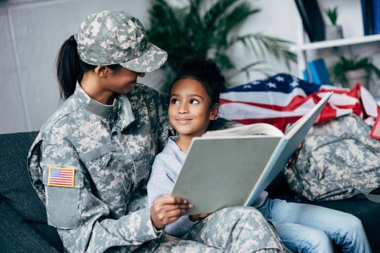 Featured image for VA Education Benefits for Dependents and Survivors, showing a female soldier with her daughter reading together in their home