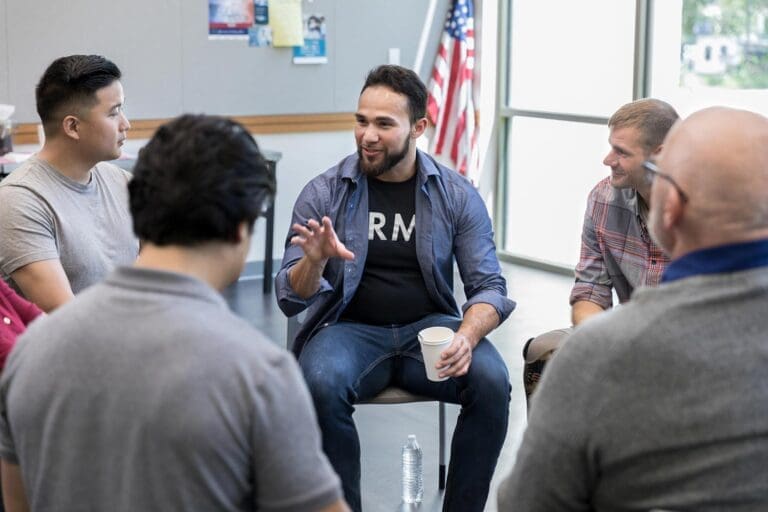 Featured image for Veteran Jobs, showing a Veteran leading a group meeting in a community center
