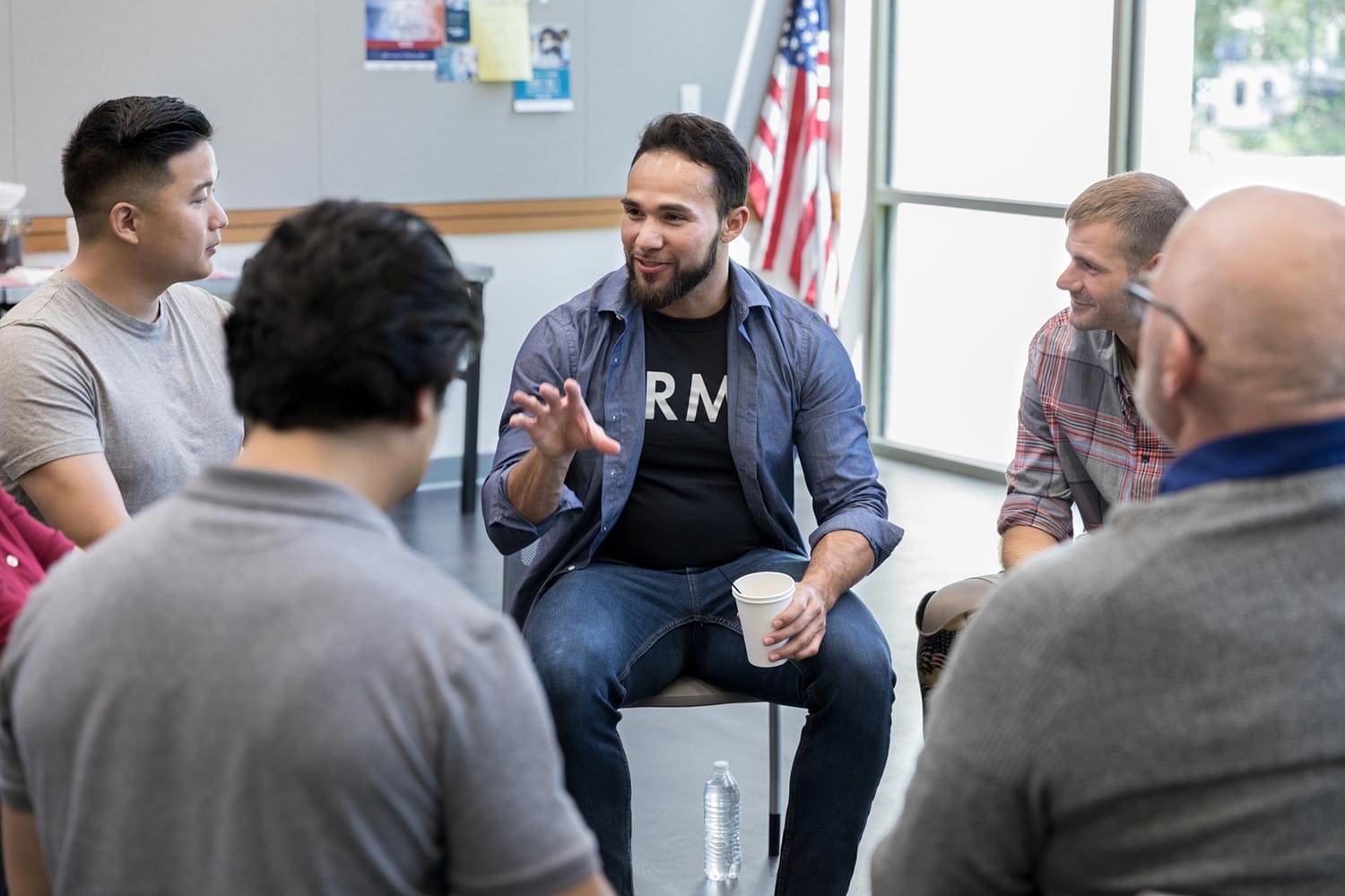 Featured image for Veteran Jobs, showing a Veteran leading a group meeting in a community center