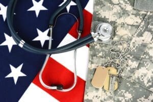Featured image for TRICARE for Active Duty, showing a stethoscope on a flag of the United States and a military dog tag on a military uniform